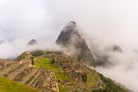 马丘比被从开放的云层中射出的第一缕柔和阳光照亮雾云和雾构成了一个田园诗般的梦幻框架印加人的城市是秘鲁访问量最大背景图片