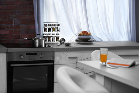 现代厨房内饰窗边配有白色家具和电炉图片