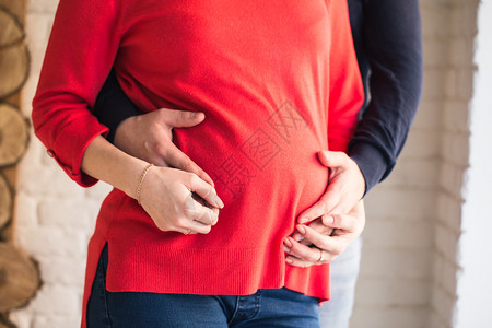 孕妇的腹部父母的手放在腹部图片