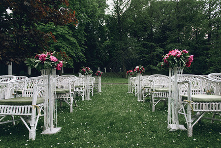 在后院背景的婚礼仪式上配着鲜花的白色餐桌椅盛年优雅时尚图片