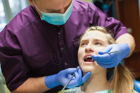 牙医在牙医那里检查病人的牙齿图片