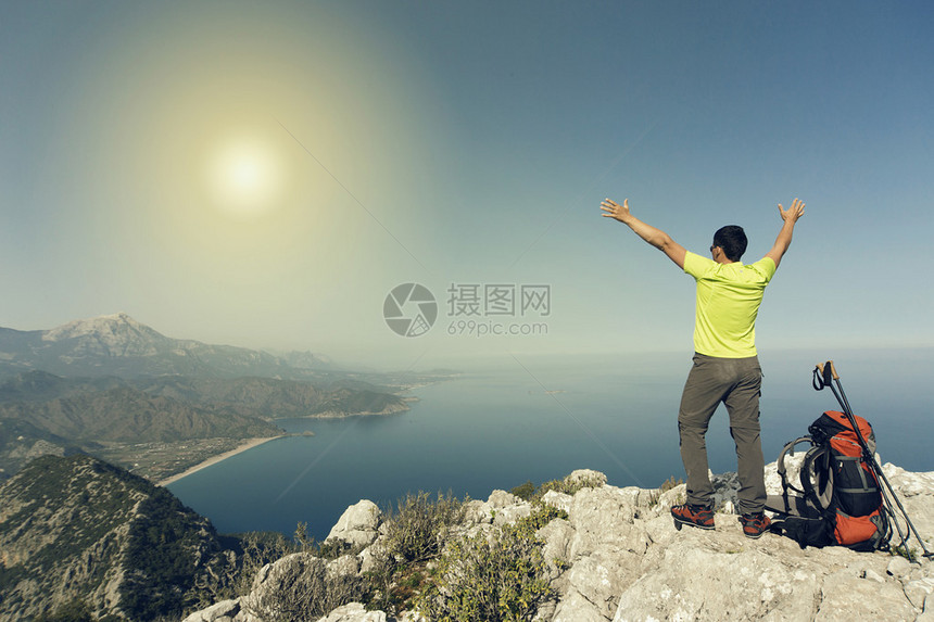 年轻人背着包在山顶上在阳图片