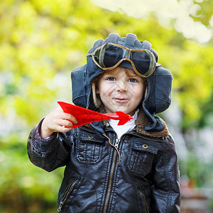 快乐的小男孩戴着飞行员头盔和制服图片