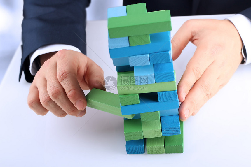 规划风险和策略在商业中商人出木块从一座塔图片