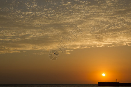 日落时在海面上空飞行的飞图片