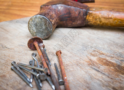 木头上的旧锤子和钉子图片