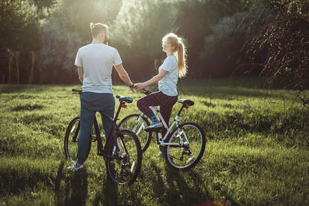 相爱的年轻美人情侣与自行车一起走着拥抱和看着对方快乐和幸福的概念是图片