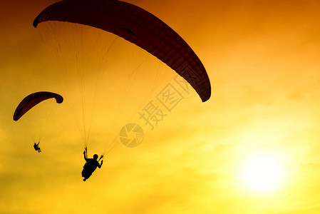 降落伞在日落背景上的剪影图片