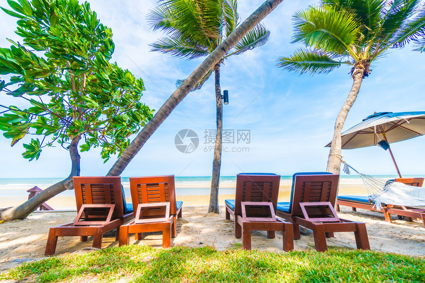 在美丽的热带海滩和海洋的伞状和椅子上图片