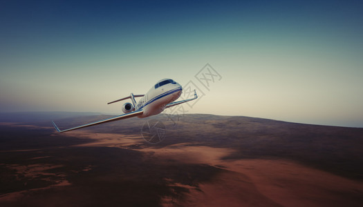 白色豪华通用设计私人喷气式飞机在地球表面下的天空中飞行的照片无人居住的沙漠山脉背景商务旅行图片水平的效果技术高清图片素材