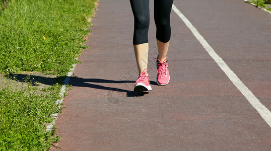 选择焦点跑步者脚特写运动员在体育场的慢跑道上跑步跑鞋图片