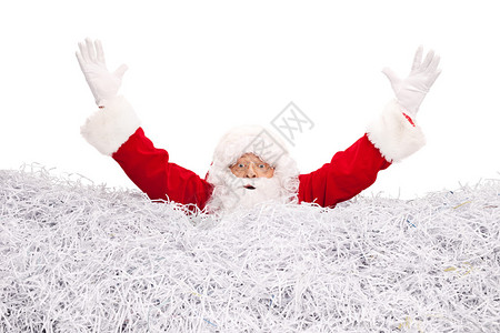 电影演播室拍摄的圣诞老人溺水在一堆碎纸中被撕成碎片孤立图片