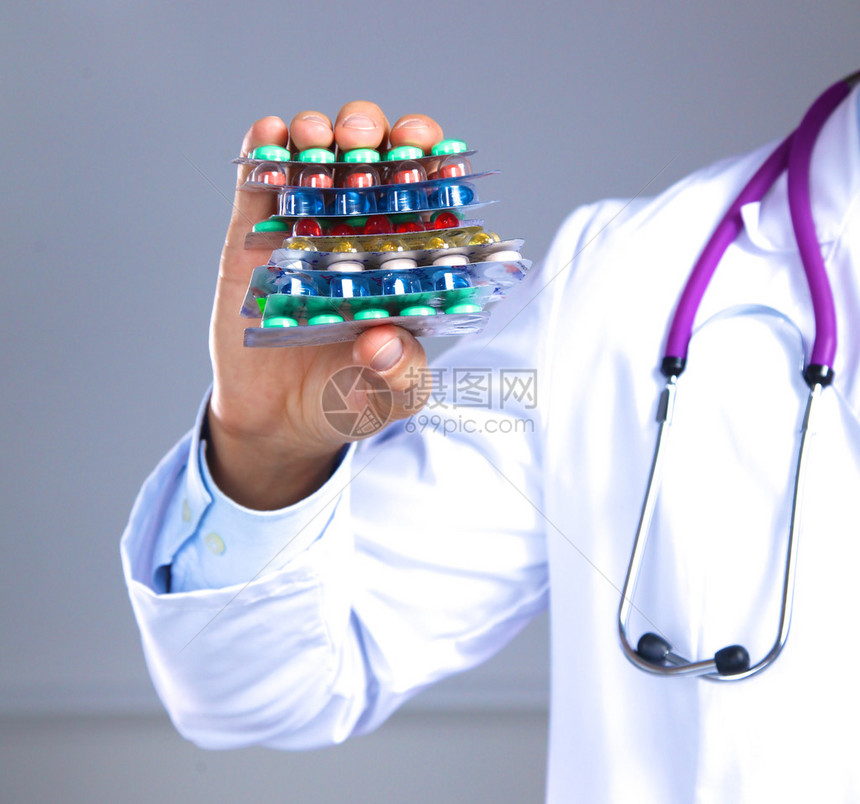 拿着许多不同药片的医生之手图片