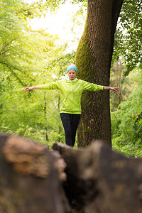 活跃的体育女在树干上保持平衡图片