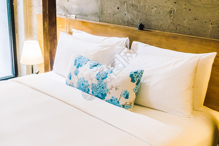 在美丽的室内卧室装饰床上的枕头图片