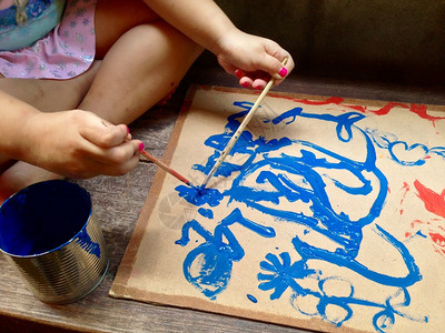 小女孩手绘水彩在纸板上图片