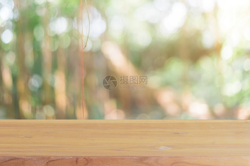 在模糊的背景前的木板空桌子森林中模糊树木上的透视棕色木材可用于模拟展示或蒙太奇您的产品春暖花开的季图片