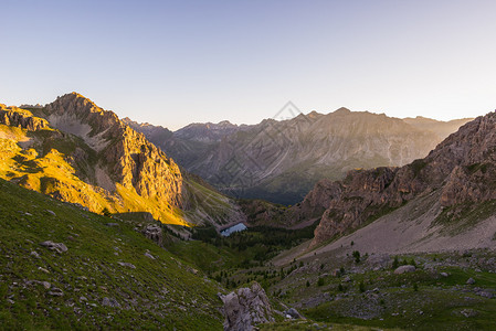 高山草甸和牧场在日落时分位于高海拔山脉中图片