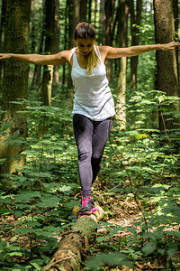 在路上的树林里的运动女运动员慢跑前暖图片
