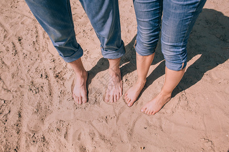 赤脚站在沙滩上的情侣图片
