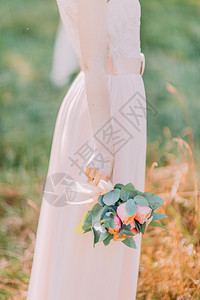 新娘在夏日森林穿着白色礼服手握着结图片