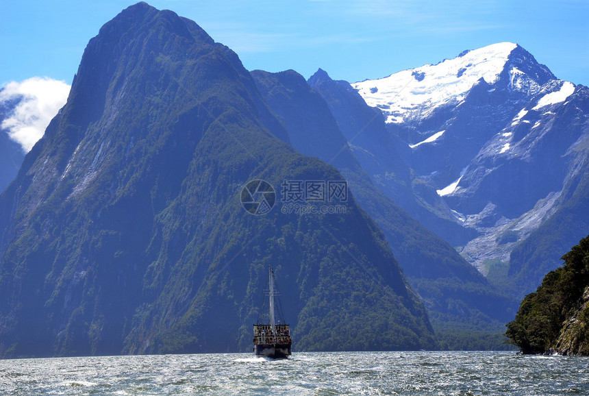新西兰南阿尔卑斯山的密尔福德湾高座船与山脉图片