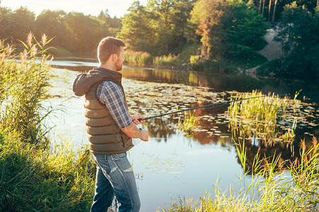 在河里钓鱼的渔夫周末男人霍比闲暇和活跃的暑假和秋天概念农村背景图片