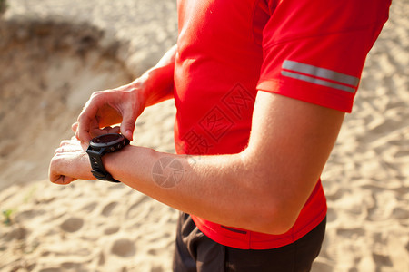 跑步者在山路上看着运动手表智能手表图片