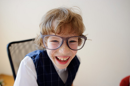 戴着大眼镜的滑稽小男生漫不经心地笑着他心情很好图片