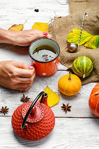 手中的茶和南瓜的秋季装饰图片