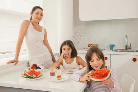 母亲有子女的儿童享受美味水果甜点图片