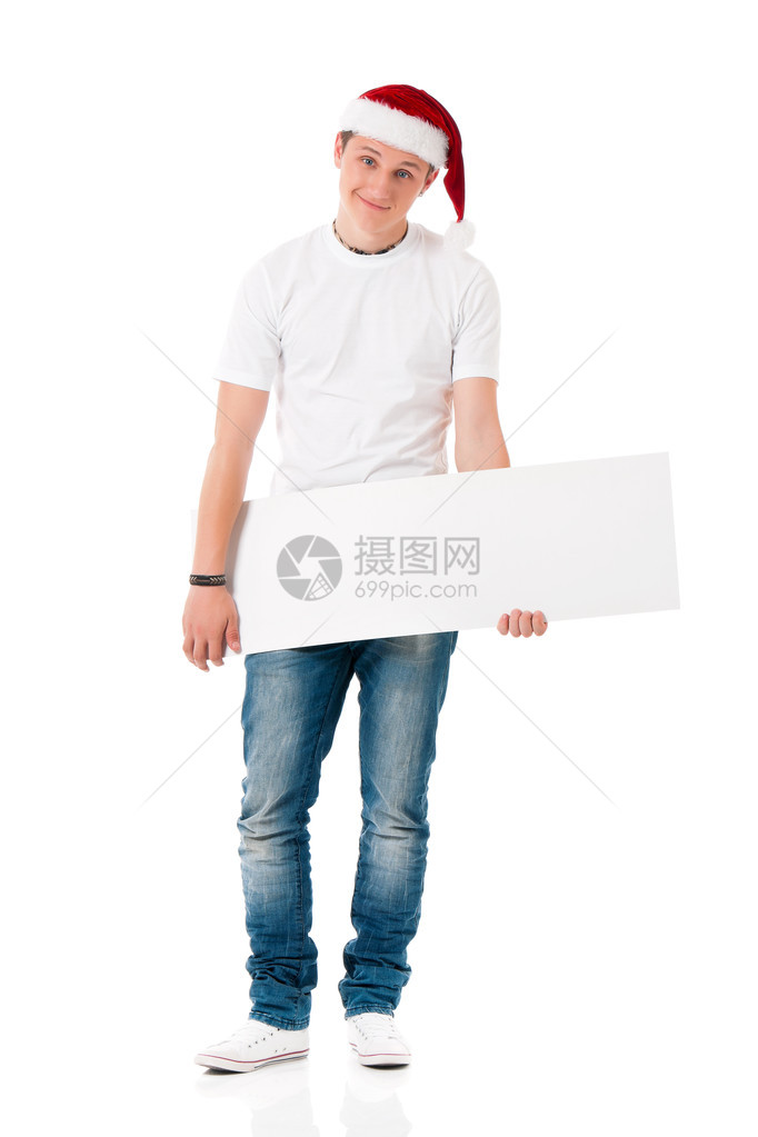 为圣诞老人戴圣诞帽的白种人少年在白色t恤与孤立的白色背景上的空白符号成功的男孩戴着圣诞老人的帽图片