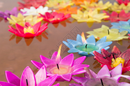漂浮在水面上的莲花形状的彩色蜡烛背景图片