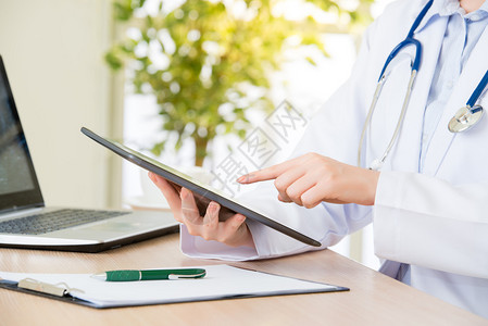 医生使用数字平板电脑研究患者的医疗案例医疗保健和医学概念医图片