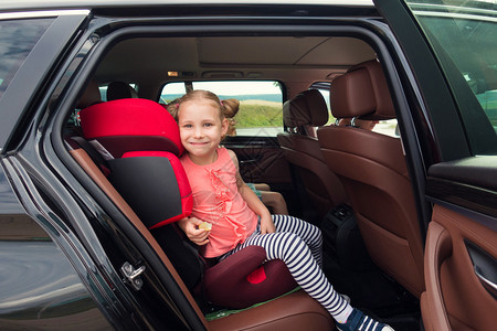 快乐的小女孩坐在汽车座椅上图片