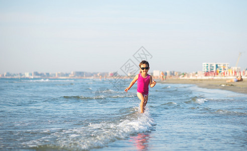 海边浪中奔跑的可爱孩子图片