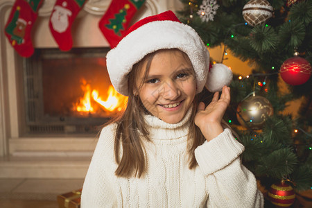 穿着白色毛衣和圣诞老人帽子的可爱女孩肖像图片