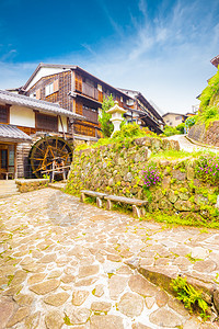 传统的木屋和水车沿着日本马込车站镇历史悠久的江户时代中山道这条经过精心修复的路段排列着石背景图片