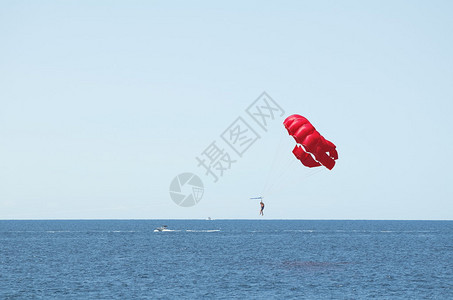 红色降落伞跳海和湛蓝的天空图片