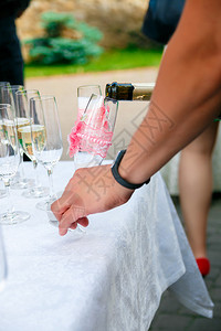 男人的手在酒杯里倒香槟酒杯背景图片