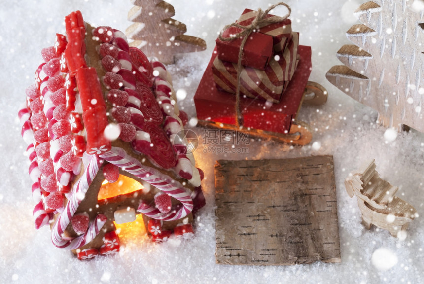 带有广告复制空间的标签雪地上的姜饼屋与圣诞树和驼鹿等圣诞装饰雪橇与圣诞礼物图片