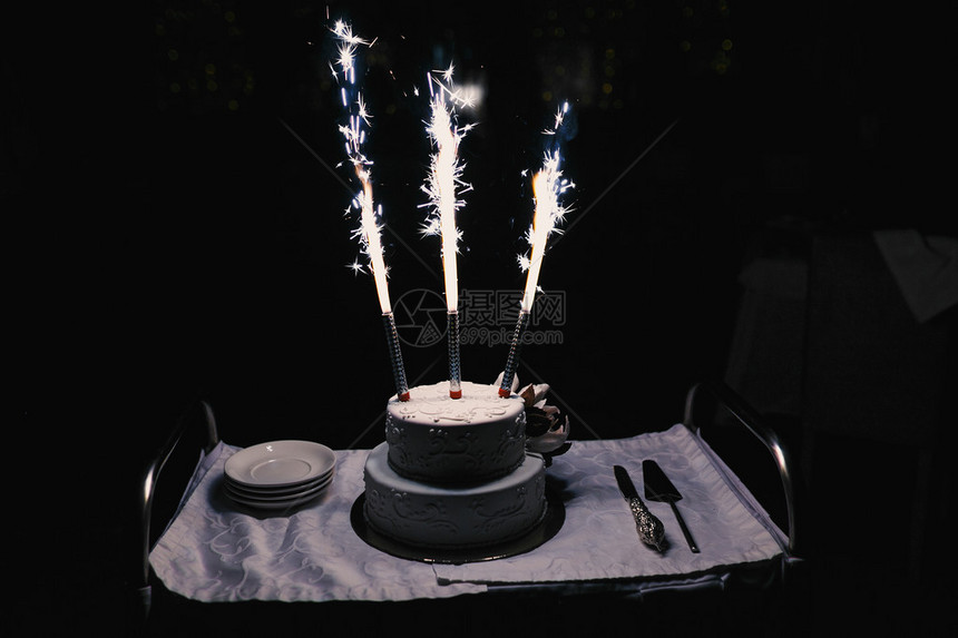 餐桌上有烟火摊的婚礼蛋糕图片