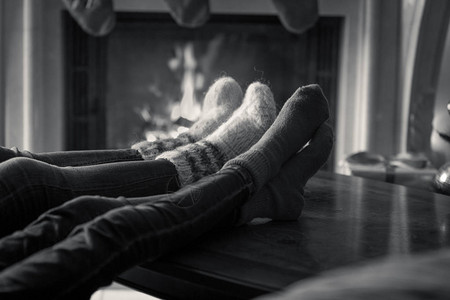 穿袜子的家庭在壁炉房子里放松的黑人和图片