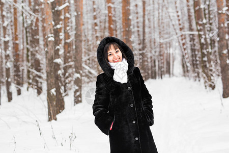 女人穿着温暖的大衣在森图片