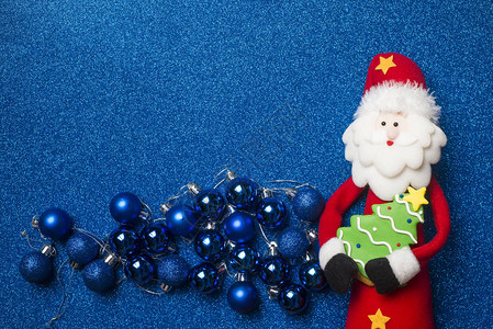 有趣的圣诞老人圣诞卡圣诞老人可爱的树和蓝色闪光背景上的球图片