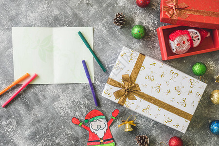 礼物盒的顶端景色圣诞装饰品和卡片在灰红背景图片
