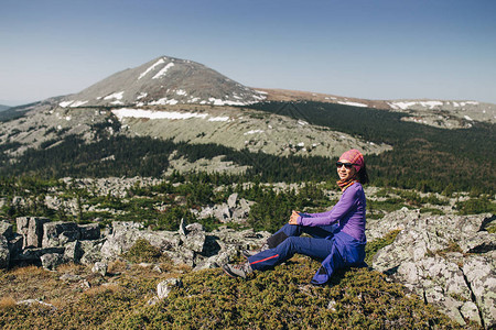 妇女旅行者在岩石上休息徒步旅行和旅游图片