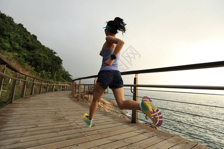 在海边奔跑的年轻健身女子越野跑者图片