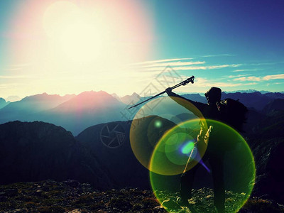 手里拿着杆子落基山脉的晴朗天气背着大背包的徒步旅行者站在迷雾笼罩的山谷上方背景图片