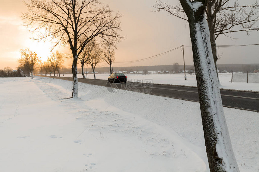 冬天和白雪皑的村庄景观与道路前往图片